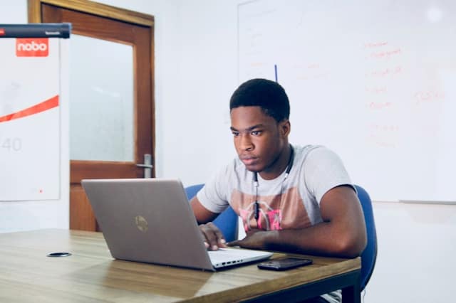 man in grey shirt using laptop